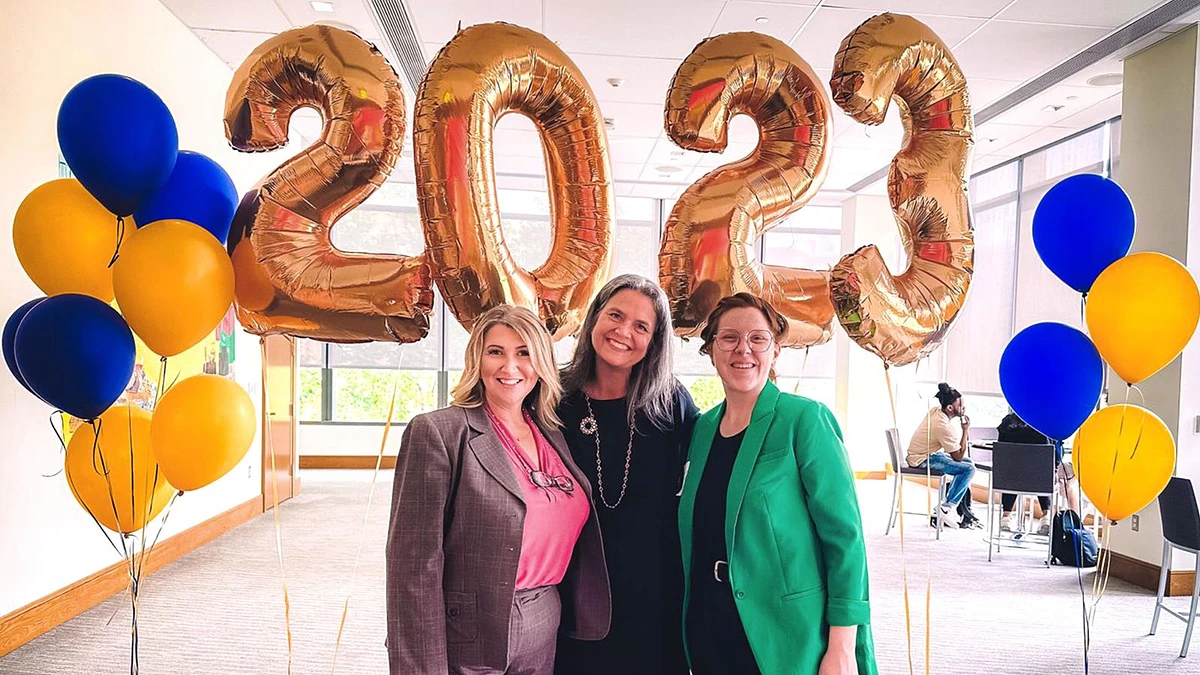 alt="3 women in front of 2023 year Balloons"