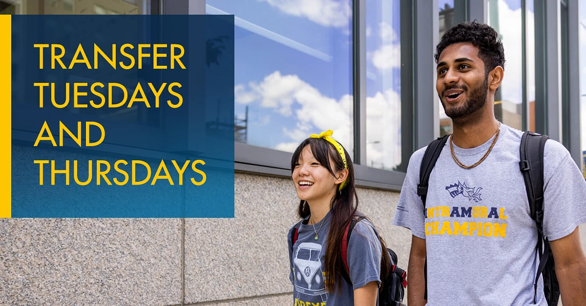 Two students walking by a building are smiling, with a sign beside them saying "Transfer Tuesdays and Thursdays."