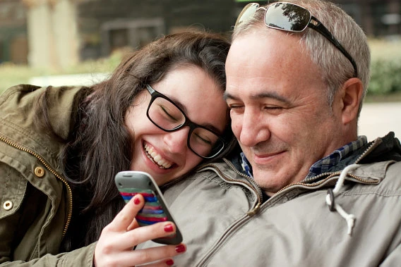 Student looking at phone with father