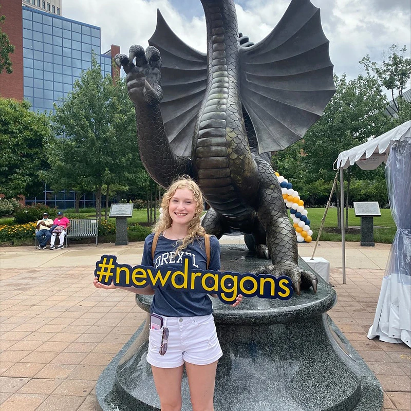 Drexel student, Victoria Miller, holding a "#newdragons" sign